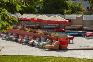 eine Reihe von Stühlen und Sonnenschirmen neben einem Pool in der Unterkunft Dreams Calvia Mallorca in Magaluf