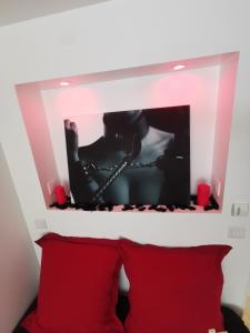 a mirror above a bed with two red pillows at Suite 50 Nuances avec Jacuzzi Privatif Dark Room Perpignan in Villeneuve-de-la-Raho