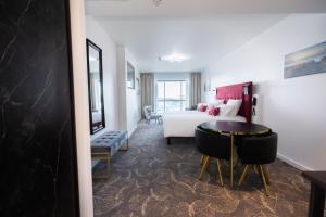 um quarto de hotel com uma cama e uma mesa em Le Barracuda & Spa, Centre Port, pieds dans l'eau, vue mer em Brest