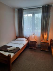 1 Schlafzimmer mit 2 Betten und einem großen Fenster in der Unterkunft Hotel Zabawa in Zabawa
