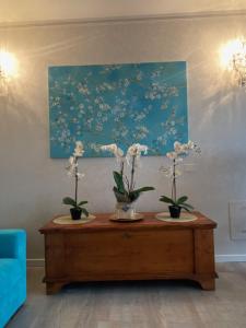 un tavolo con due vasi con sopra dei fiori di Garda Blue Lake Home Luxury Appartment a Desenzano del Garda