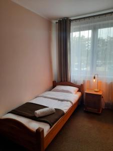 a small bedroom with a bed with a window at Hotel Zabawa in Zabawa