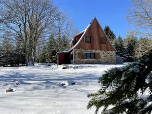 dom z czerwonym dachem w śniegu w obiekcie Horská chata Svahová w mieście Boleboř