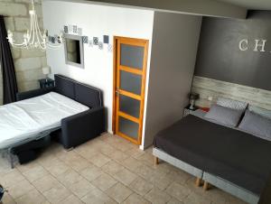 een slaapkamer met 2 bedden en een deur bij Le Gîte des Marguerites in Montrichard