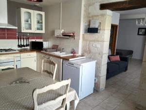 eine Küche mit einer Spüle und einem Tisch mit einer Arbeitsplatte in der Unterkunft Le Gîte des Marguerites in Montrichard