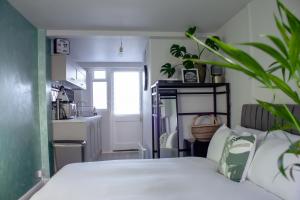 a bedroom with a white bed and a kitchen at Annex By The Sea in Littlehampton