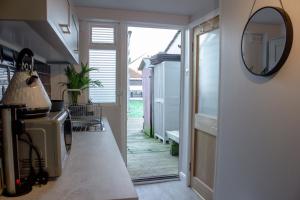 a kitchen with a mirror on the wall and a hallway at Annex By The Sea in Littlehampton