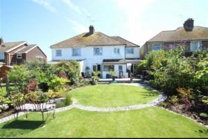 a large white house with a lawn in front of it at Annex By The Sea in Littlehampton