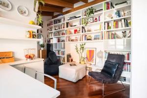 uma sala de estar com prateleiras e cadeiras brancas em Le Domus Milano_Attic with terrace em Milão