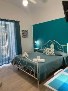Un dormitorio con una cama con una pared azul. en Casa Vittoria, en Palermo