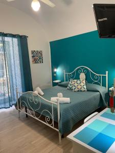 Un dormitorio con una cama con una pared azul. en Casa Vittoria, en Palermo