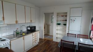 cocina con armarios blancos, mesa y fogones en Falkenberg /Vinberg, en Vinberg