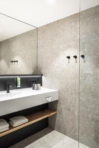 a bathroom with a sink and a shower at Stadthotel Goldenes Schiff in Bad Ischl