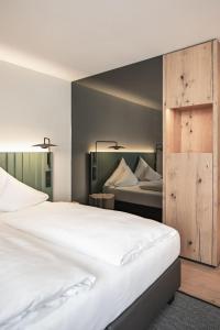 a bedroom with two beds and a wooden door at Stadthotel Goldenes Schiff in Bad Ischl