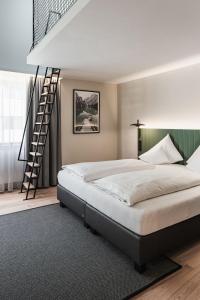 a bedroom with a large bed and a staircase at Stadthotel Goldenes Schiff in Bad Ischl