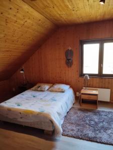 - une chambre avec un grand lit dans un mur en bois dans l'établissement Chambre d'hôtes à la campagne "Le coudry", à Serley