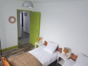 sala de estar con sofá y puerta verde en Maison au calme 2 à 300 m de la plage 2 chambres, en La Cotinière