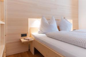ein Schlafzimmer mit einem weißen Bett mit blauen Kissen in der Unterkunft BergZeit Schoppernau in Schoppernau