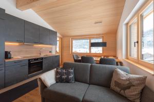 ein Wohnzimmer mit einem Sofa und einer Küche in der Unterkunft BergZeit Schoppernau in Schoppernau