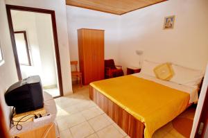 a hotel room with a bed and a tv at Mon Perin Castrum - Studio Apartment Adriano in Bale