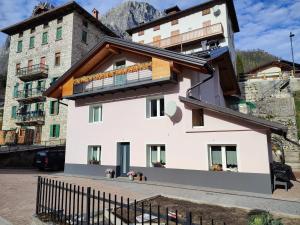 - un bâtiment blanc avec un balcon au-dessus dans l'établissement Sweet Dolomites Sauna & Jacuzzi, à Agordo