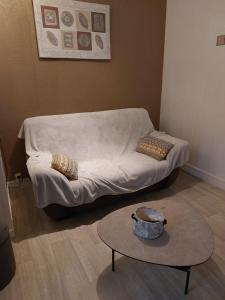 - un canapé blanc dans une chambre avec une table dans l'établissement le petit dieppois, à Dieppe