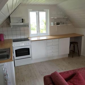 cocina con armarios blancos y encimera en Lys og lettstelt leilighet med utsikt over byen, en Sandefjord