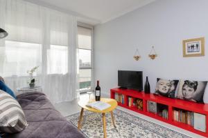 a living room with a couch and a red shelf at Przymorze Falowiec Apartment by Renters in Gdańsk