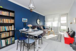 a living room with blue walls and a table and chairs at Przymorze Falowiec Apartment by Renters in Gdańsk