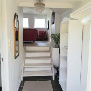 een trap in een tiny house met een woonkamer bij Lys og lettstelt leilighet med utsikt over byen in Sandefjord