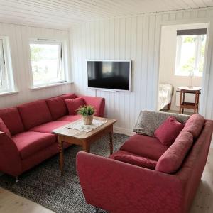 a living room with a red couch and a table at Lys og lettstelt leilighet med utsikt over byen in Sandefjord