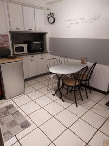 a kitchen with a table and chairs on a tiled floor at le petit dieppois in Dieppe