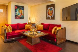 a living room with a red couch and a table at Le Zenith Hotel & Spa in Casablanca