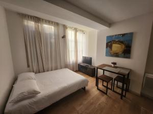 sypialnia z łóżkiem, stołem i oknem w obiekcie Pied à terre tout confort w mieście Bar-le-Duc