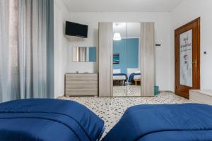 ein Schlafzimmer mit einem blauen Bett und einem Spiegel in der Unterkunft Dorotea in Palermo