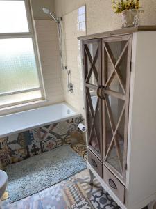 La salle de bains est pourvue d'une baignoire et d'une armoire avec une fenêtre. dans l'établissement שלווה בהר, à Malkiyya