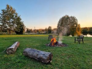 un fuego en un campo con troncos en la hierba en Siedlisko Mazury, 