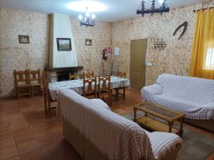 ein Wohnzimmer mit Sofas, einem Tisch und einem Kamin in der Unterkunft Casas Rurales Ivan El Penas in Benizar
