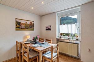 a dining room with a table and chairs and a window at Am Sersbach in Forbach