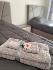 een handdoek met een bloem op een bed bij Proche de la plage et du métro, 1 place de garage in Póvoa de Varzim
