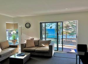 ein Wohnzimmer mit einem Sofa und einem großen Fenster in der Unterkunft Phillip Island Holiday Apartments in Cowes