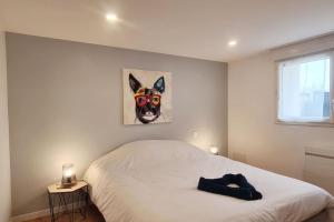 1 dormitorio con 1 cama con una foto de un perro en la pared en L'Atelier d'Emilie, en Bessines