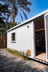 une petite maison blanche avec une grande porte coulissante dans l'établissement Unique Pod Stay, à Durban