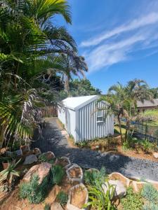 un cobertizo blanco con palmeras y rocas en Unique Pod Stay, en Durban