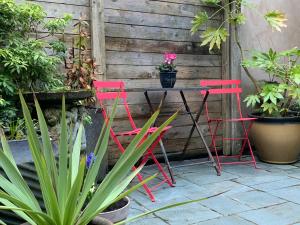 2 sillas rosas y una mesa en un jardín en South Lakes Townhouse with Sauna en Ulverston