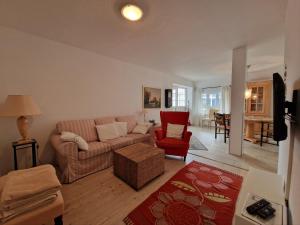 un soggiorno con divano e sedia rossa di Teich-11b a Grossenbrode