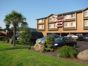 a hotel with cars parked in a parking lot at Clackamas Inn and Suites in Clackamas