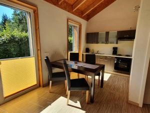 cocina con mesa, sillas y ventana en Ferienhäuser & Bungalows - Naturcamp Meyersgrund im Thüringer Wald, en Ilmenau