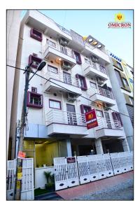 Un grand bâtiment blanc avec balcon se trouve dans une rue. dans l'établissement Hotel Omicron 1 BHK Studio room, à Bangalore