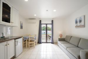 a kitchen and living room with a couch and a table at Apartamentos Vale de Carros by Umbral in Albufeira